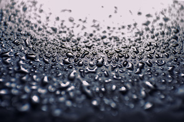 oil and water drops on black glass surface abstract background