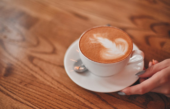A cup of cappuccino on a wooden table