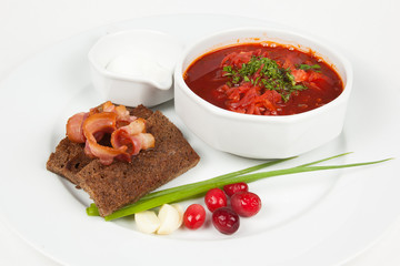 Traditional Ukrainian Russian borscht with white beans on the bowl. Beetroot soup. With bacon and toast. Plate of red beet root soup borsch on white background.