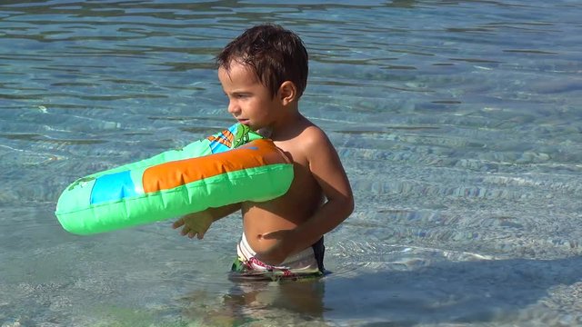 4K Small child tries to inflate a blown out air ring