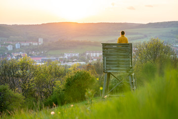 Woman in a yellow jacket enjoying a beautiful sunset over Jena in Thuringia 