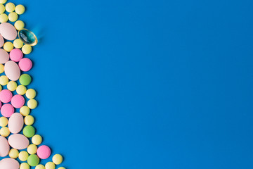 Pills served as a healthy meal. Drug capsule on white plate on blue background