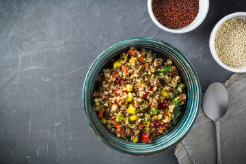 Quinoa salad bowl with colorful vegetables: green beans, carrot, corn, bell pepper, peas and cups with quinoa seeds. Clean eating, healthy vegan food concept. Top view, flat lay, copy space.
