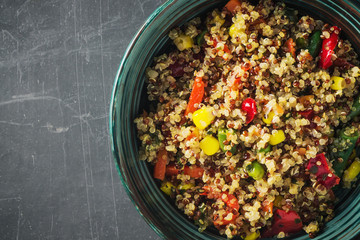 Closeup of quinoa salad bowl with colorful vegetables: green beans, carrot, corn, bell pepper,...