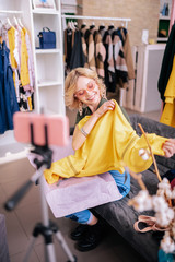 Blogger filming blog showing new yellow sweatshirt