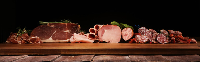 cold meat assortment with delicious salami and  fresh herbs . Variety of meat products including...