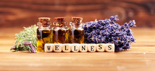 lavender oil in a glass bottle on a background of fresh flowers.
