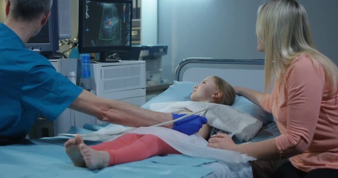 Doctor examining girl with ultrasound