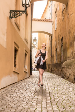 Happy young woman independent solo traveler sightseeing in European city, Prague, Czech Republic