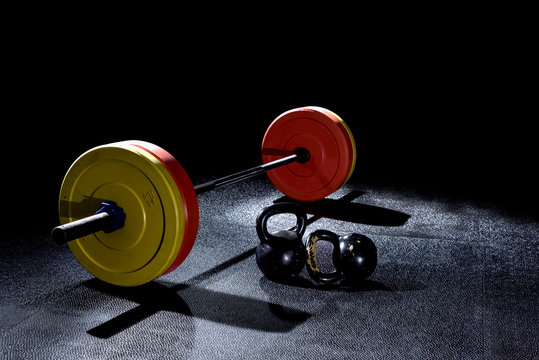 Bumper plates in gym with dramatic lighting