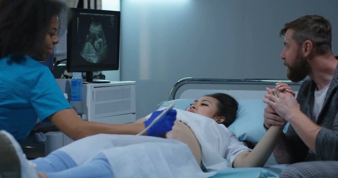 Doctor examining pregnant woman with ultrasound