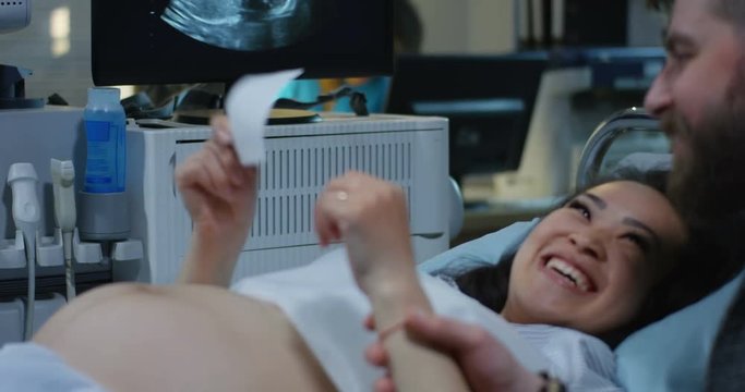 Couple looking at ultrasound photo of baby