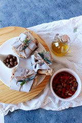 Bocadillos de tortilla de pisto sobre plato de madera y fondo azul