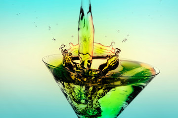 Beautiful splash of liquid from a martini glass on a blue gradient background.