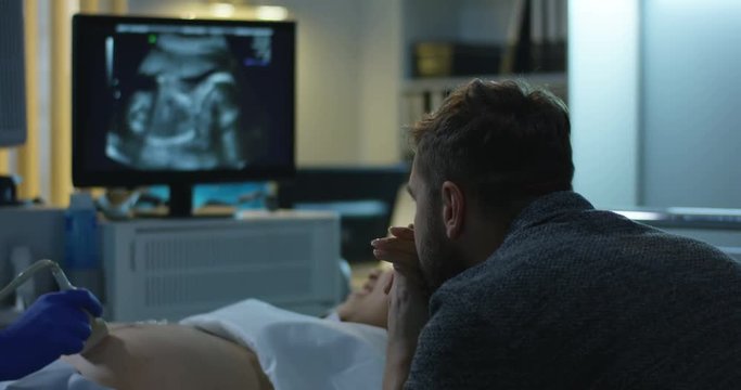 Couple watching ultrasound image of future child
