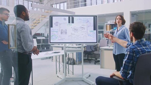In the In Industrial Design Facility Team of Engineers and Technicians have a Meeting, Female Specialist Leads Briefing, Talks and Draws on Digital Interactive Whiteboard with Car Prototype Concepts