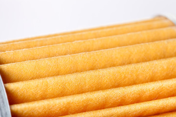 orange paper car filter closeup of the spare part.
