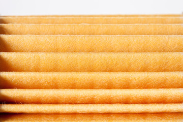 yellow paper car filter closeup texture fan folds of the spare part.
