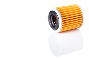 yellow paper car filter lies on its side on a white background with reflection, isolated spare part on a white background with copy space.