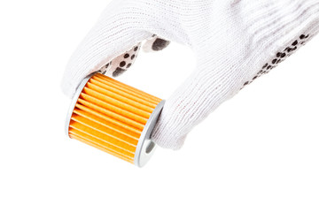 Orange automobile paper filter holds the hand of an engineer in white glove on a white background closeup.