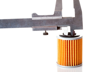 Measurements of the internal size and diameter of the car filter caliper, isolated spare part paper orange filter and caliper on a white background.