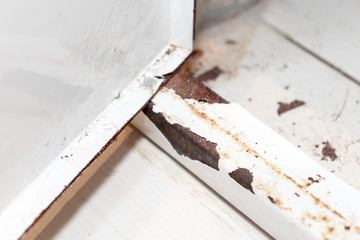 Rusty metal door of sanitary hatch with peeling paint as a result of humidity in bathroom, shallow focus