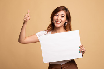 Fototapeta premium Young Asian woman show thumbs up with white blank sign.