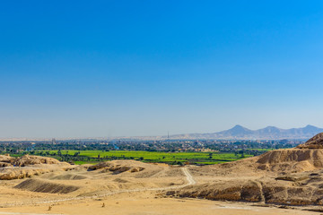 Naklejka premium Archeological site near the temple of Hatshepsut in Luxor, Egypt. Green landscape on a background