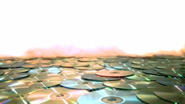 Shiny DVD CD Data disc falling on a pile. DVD Data or CD video optical discs falling onto a sea of other discs.