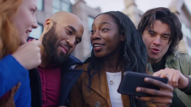 Diverse group of friends post together for a selfie on a cell phone