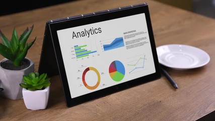 Animated colorful analytics on the laptop. Female hands holding tochpad horizontal and woman drinking coffee.