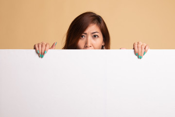 Fototapeta premium Close up of young Asian woman behind a blank sign.