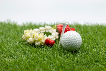 Naklejka premium Happy mother's day to golfer with golf ball and flowers are on green grass