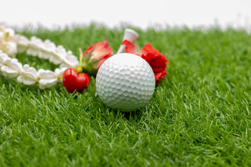 Naklejka premium Happy mother's day to golfer with golf ball and flowers are on green grass
