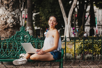 Latin Woman holding a laptop and smiling in Mexico, mexican girl