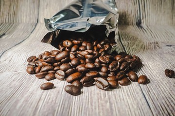 Roasted coffee beans against wooden background