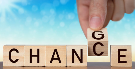 Personal development concept. Hand flip wooden cube with word "change" to "chance" Back of bokeh background