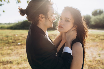 Fototapeta premium Stylish and fashionable couple spending time outdoors and flirting with each other. A man and a woman show a complex relationship and a great love for each other