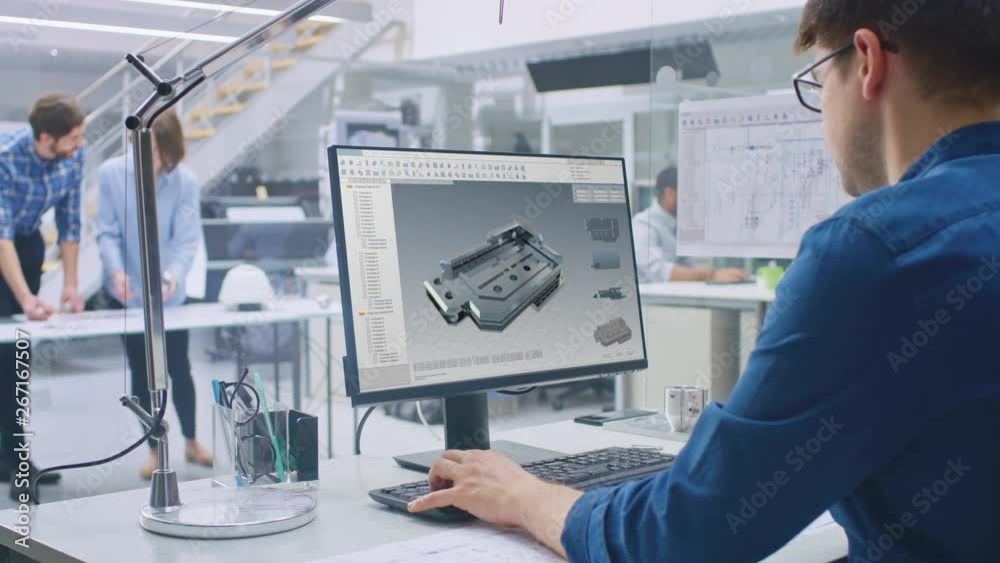 Fototapete Engineer Working on Desktop Computer, Screen Showing CAD Software with 3D Component. In the Background Engineering Facility with Blueprints and Drawings with Industrial Design. Over the Shoulder