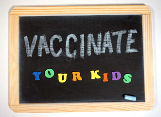 Fototapeta na wymiar Vaccinate your kids message on chalkboard