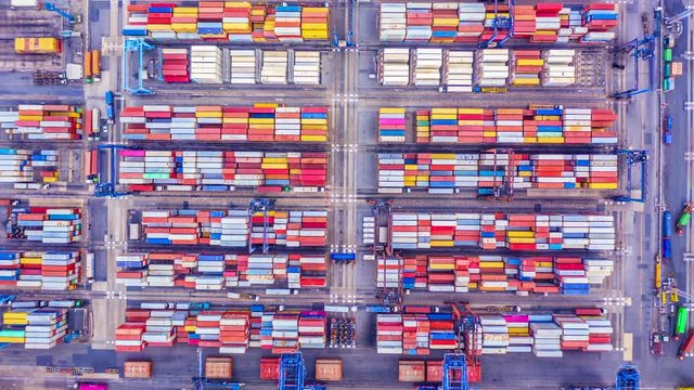 4k Hyper lapse aerial view container cargo ship loading and unloading in deep sea port, Aerial top view of logistic import export transportation business by container ship in open sea.