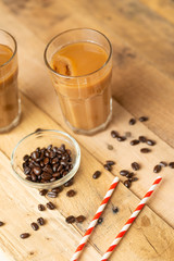 Fototapeta na wymiar Iced coffee in transparent glasses with ice and straws, on a wooden background, a cooling drink, refreshing, summer mood