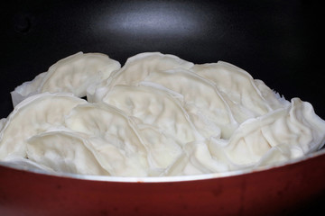 フライパンに並べた冷凍餃子（焼く前）