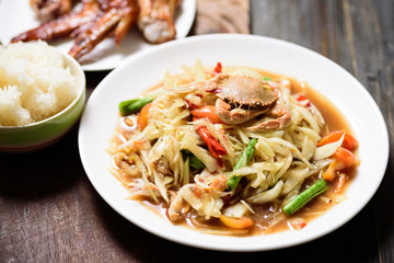 Spicy papaya salad, grilled chicken wing and sticky rice. Thai food (Som Tum)