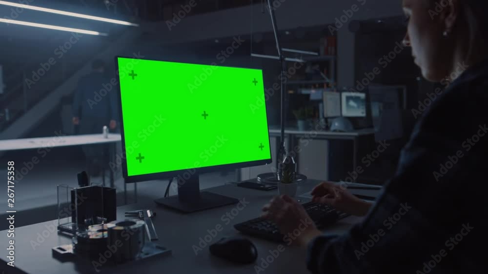 Poster Over the Shoulder Shot of Engineer Working with Green Mock-up Screen Desktop Computer. In the Background Engineering Facility at Night Blueprints and Drawings with Showing Industrial Design