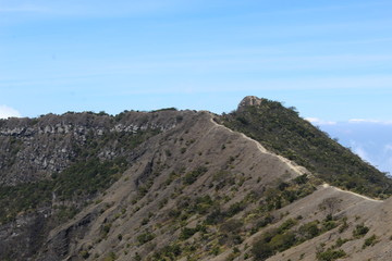 Naklejka premium the clear sky above the volcanic crater that surrounds the clouds