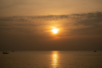 view of sunrise over the sea with fisheries boats