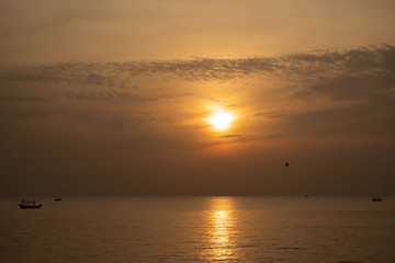 Naklejka na ściany i meble view of sunrise over the sea with fisheries boats