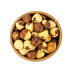 Wooden bowl with roasted hazelnuts isolated on white background. Prepared with the harvest of hazelnuts. Flat lay.