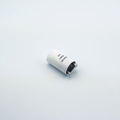 Concept photo of an electrical appliance capacitor in electrical wiring for connecting wires on a white background. Great for the catalog of a modern online store.